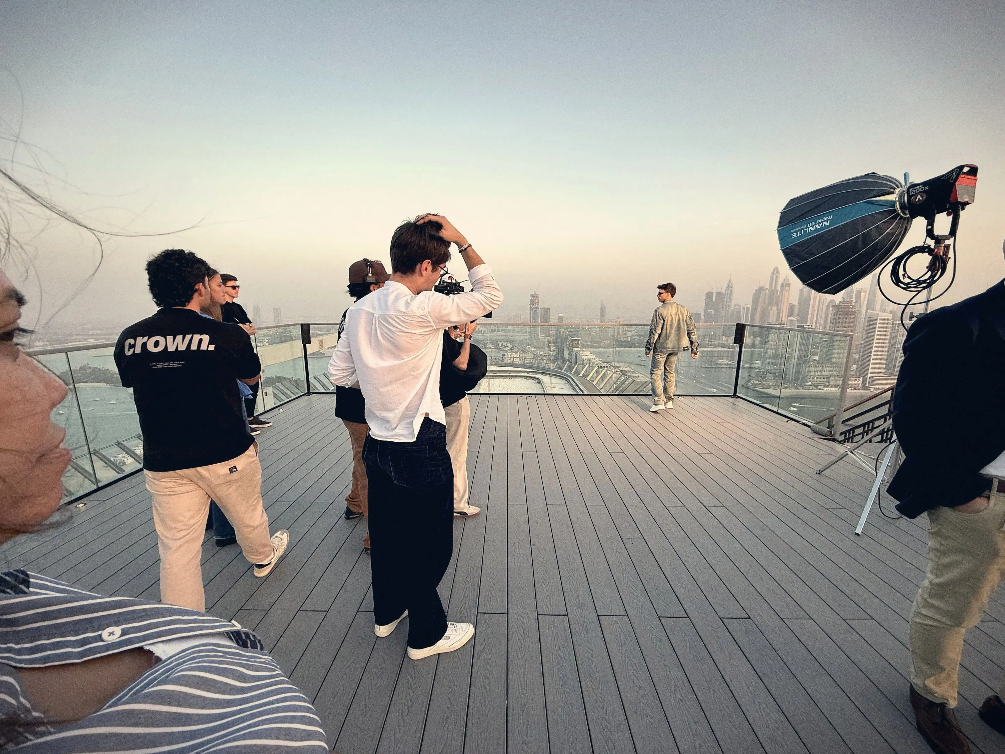 Film crew setting up a shoot on a rooftop terrace above the Dubai skyline